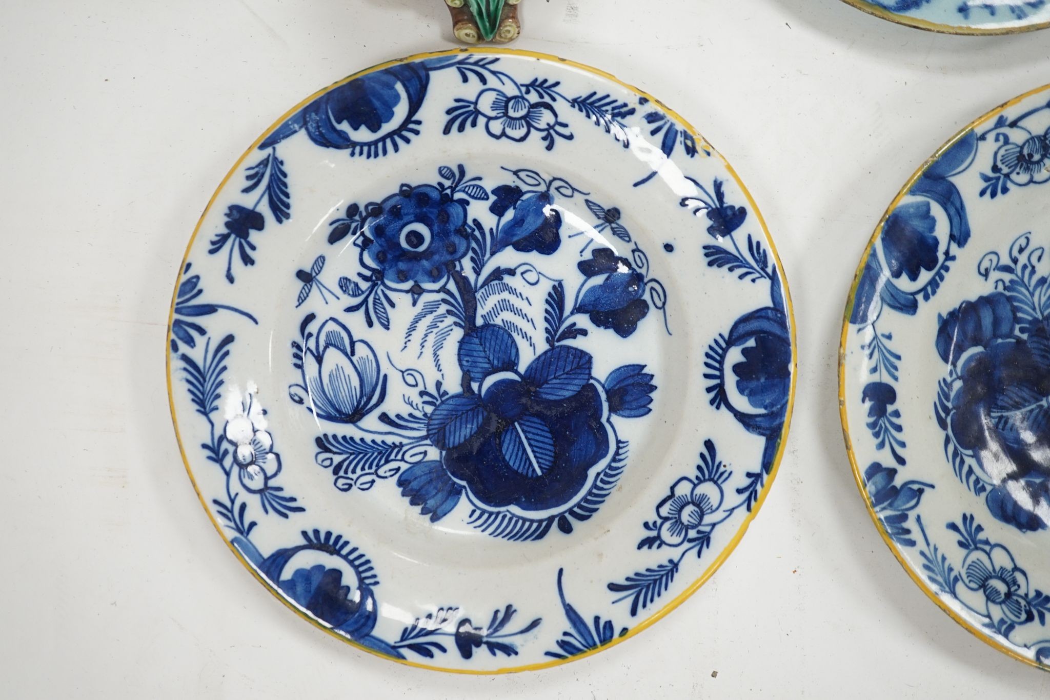 A group of 18th century delftware plates, Wedgwood majolica candlestand (a.f.) and two Victorian framed pot lids